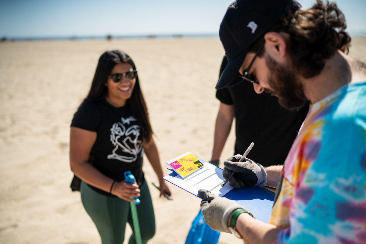 1% for the planet staff Jeff WIlson with a clipboard on the beach