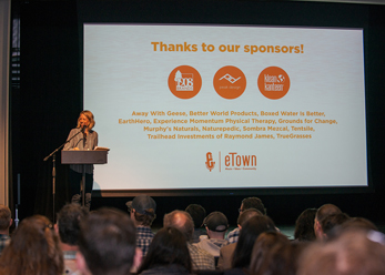 kate williams in front of a slide with our event sponsors at global summit
