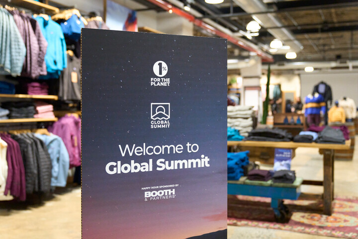 a sign at global summit happy hour showing booth as the sponsor